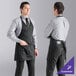 A man wearing a black Uncommon Chef tuxedo apron with pockets.
