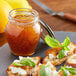 Slices of bread with Dalmatia Fig Spread next to a jar of jam on a table.