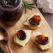 A board with food next to a jar of Dalmatia Plum Spread.