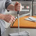 A man using a Wusthof sharpening steel to sharpen a knife.