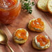 A piece of bread with Dalmatia Organic Apricot Spread on top on a table.