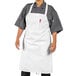 A man wearing a white Uncommon Chef bib apron.