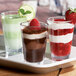 A tray with a chocolate dessert, a chocolate drink, and a dessert with a raspberry served in Carlisle Alibi dessert shot glasses.