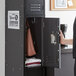 A woman opens a Regency locker to show a brown bag.