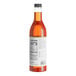 A close up of a Capora Peach Flavoring Syrup bottle with a label.