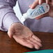 A hand squeezing Kutol hand sanitizer gel onto another hand.