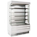 A white Turbo Air air curtain merchandiser with glass shelves.