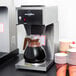 A Bloomfield commercial pourover coffee maker on a counter with cups.