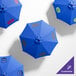 A blue California Umbrella with a black handle and black pole with a yellow and black logo.