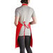A woman wearing a red Intedge bib apron.