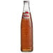 A close up of a Sidral Mundet apple soda bottle with a label on it.