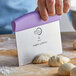 A person using a Mercer Culinary purple dough cutter to cut dough on a counter.