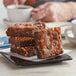 A tray of David's Cookies Reese's Peanut Butter Swirl Brownies on a table with a blurry cup of coffee.