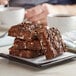 A stack of brownies with chocolate and marshmallows on a plate.
