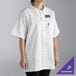 A white short-sleeve cook shirt with a collar, front snaps, and a chest pocket, featuring a customizable logo.