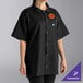 A black short-sleeve cook shirt with a collar, snap buttons, and a customizable name tag on the chest.