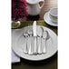 A white table set with a Sant'Andrea Bellini stainless steel table knife and flowers.