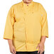 A woman wearing a yellow Uncommon Chef 3/4 Length Sleeve Chef Coat with sunflowers.