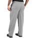 A person wearing Uncommon Chef houndstooth chef pants with their hands in their pockets.