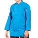 A woman wearing a cobalt blue Uncommon Chef 3/4 Length Sleeve Chef Coat.