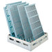 A MetroMax Q shelving unit with white plastic grids and blue plastic trays inside.