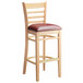 A Lancaster Table & Seating wooden ladder back bar stool with a burgundy vinyl seat.