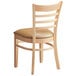 A Lancaster Table & Seating wooden chair with a light brown vinyl cushion.