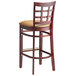 A Lancaster Table & Seating mahogany wood bar stool with a light brown vinyl cushion on the seat and back.