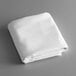 A folded white rectangular Intedge table cover.
