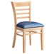 A Lancaster Table & Seating wood ladder back chair with a navy vinyl cushion.