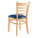 A Lancaster Table & Seating wooden restaurant chair with navy vinyl seat and ladder back.
