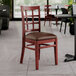 A Lancaster Table & Seating mahogany wood chair with dark brown vinyl seat.