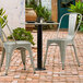 A table and chairs on a brick patio with a Lancaster Table & Seating Excalibur replacement table base bolt.