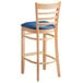 A Lancaster Table & Seating wooden bar stool with a navy vinyl seat.