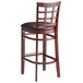 A Lancaster Table & Seating mahogany wood bar stool with a dark brown vinyl seat.