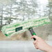a hand holding a green and white mop