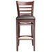 A Lancaster Table & Seating mahogany wood bar stool with dark brown vinyl seat.