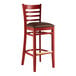 A mahogany wood Lancaster Table & Seating ladder back bar stool with a dark brown vinyl seat.