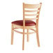 A Lancaster Table & Seating wooden ladder back chair with a burgundy vinyl seat.