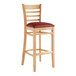 A Lancaster Table & Seating wooden bar stool with a burgundy vinyl seat.
