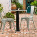 A Lancaster Table & Seating Excalibur table base column on a table with a pot and salt and pepper shakers on a brick patio.