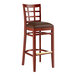 A Lancaster Table & Seating mahogany wood bar stool with dark brown vinyl seat.