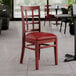 A Lancaster Table & Seating mahogany wood chair with a burgundy vinyl seat.