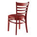 A Lancaster Table & Seating mahogany wood restaurant chair with a burgundy vinyl seat and ladder back.