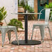 A Lancaster Table & Seating Excalibur outdoor table base on a brick patio.