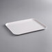 A white rectangular MFG Tray on a gray surface.