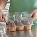 A woman holding a Choice plastic container with a cupcake inside.