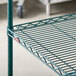 A Metroseal 3 green metal wire shelf with a red label.