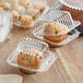 A group of muffins in clear plastic containers.