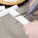 A person cutting a cake with a Wilton 6" Plastic Hidden Cake Pillar.